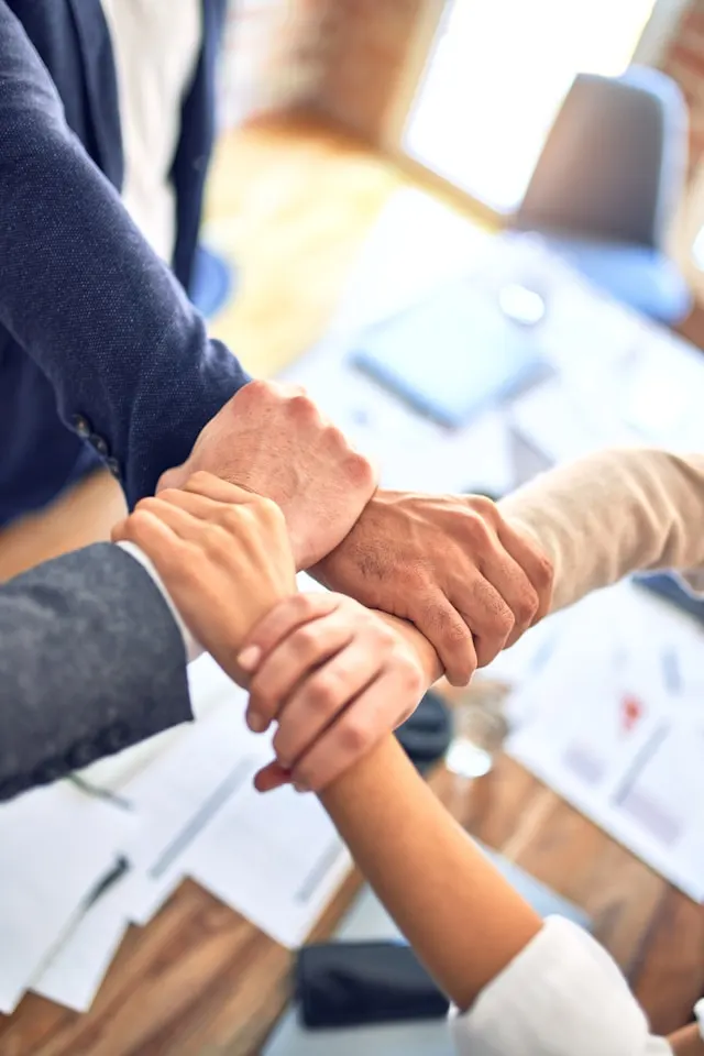 Equipo legal uniendo manos en solidaridad